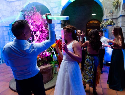 Los novios bailando con palos de luces en la boda